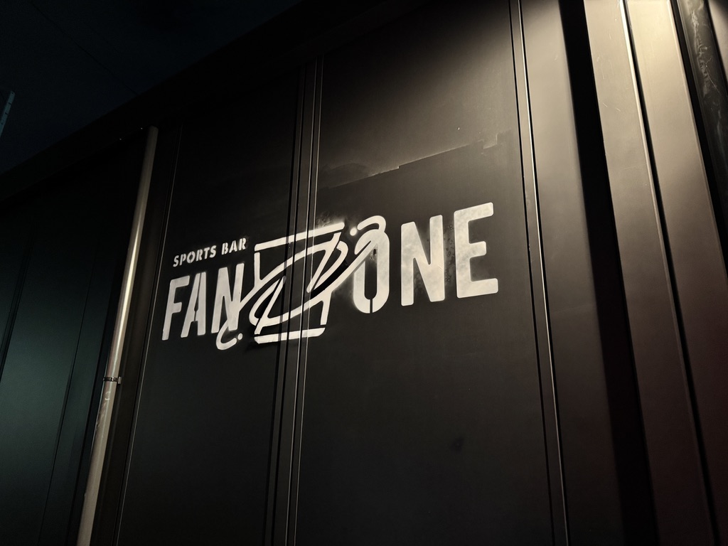 Sports Bar FANZONE の店内。ネオンサインとバーカウンター